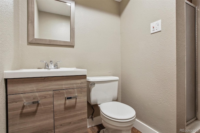 10505 Clarkson St, Northglenn, CO 80233 - bathroom with toilet, vanity, a textured wall, and wood finished floors