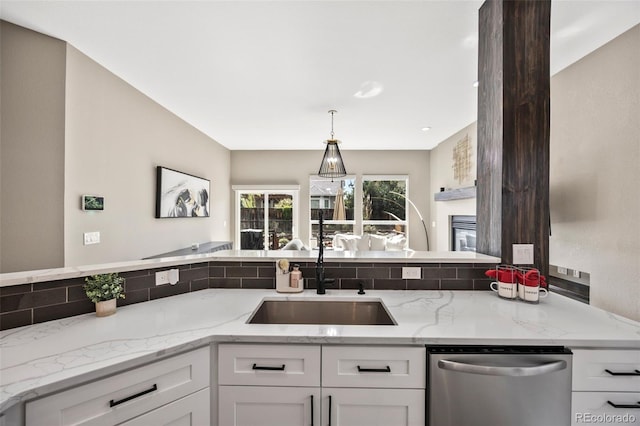 10553 Stonemeadow Dr, Parker, CO 80134 - kitchen with dishwasher, white cabinets, light stone countertops, and hanging light fixtures