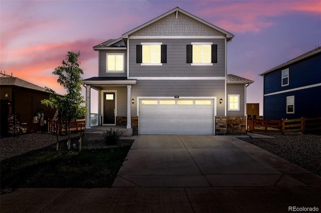 226 Racer St, Bennett, CO 80102 - view of front of house with stone siding, driveway, and a garage