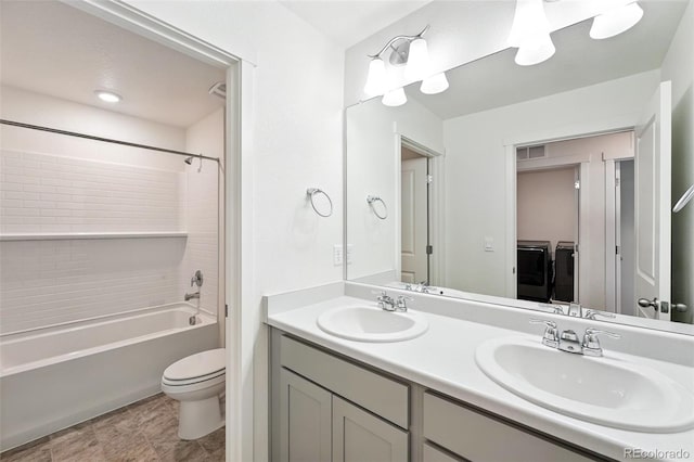 226 Racer St, Bennett, CO 80102 - bathroom with separate washer and dryer, double vanity, and bathtub / shower combination