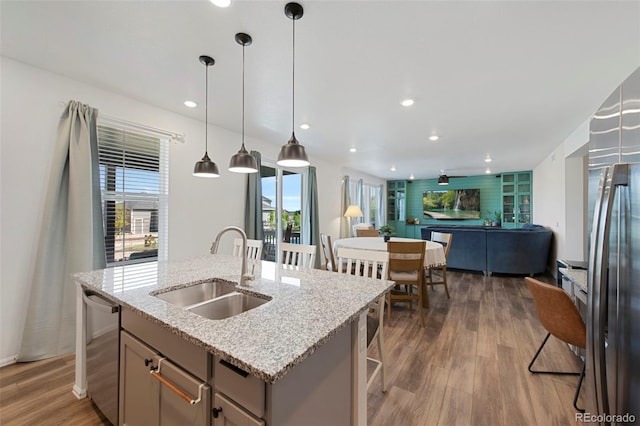12826 Lake Port St, Longmont, CO 80504 - kitchen with open floor plan, gray cabinets, stainless steel appliances, wood finished floors, and a center island with sink