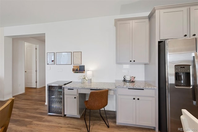 12826 Lake Port St, Longmont, CO 80504 - kitchen with stainless steel fridge, wine cooler, light wood-style floors, and light stone counters