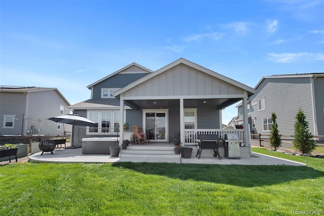 12826 Lake Port St, Longmont, CO 80504 - rear view of house featuring board and batten siding, a patio, a lawn, and a hot tub