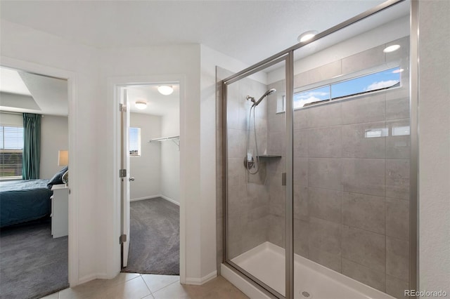 12826 Lake Port St, Longmont, CO 80504 - ensuite bathroom featuring a shower stall, tile patterned flooring, and a walk in closet