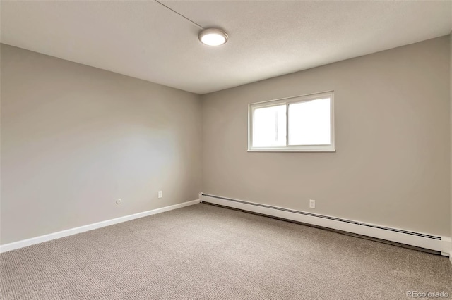 carpeted spare room with a baseboard heating unit