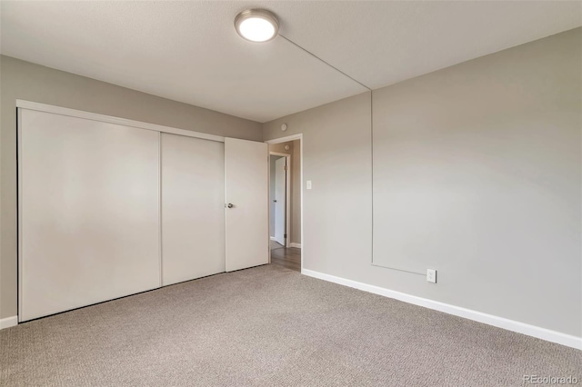 unfurnished bedroom with a closet and carpet flooring