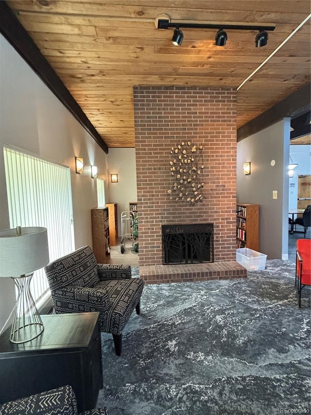 living room featuring wood ceiling, a brick fireplace, carpet, and track lighting