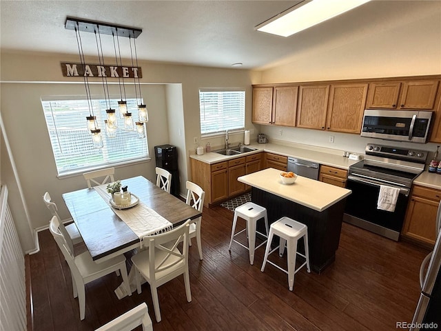 3771 S Kirk Way, Aurora, CO 80013 - kitchen featuring stainless steel appliances, light countertops, a breakfast bar area, and dark wood finished floors