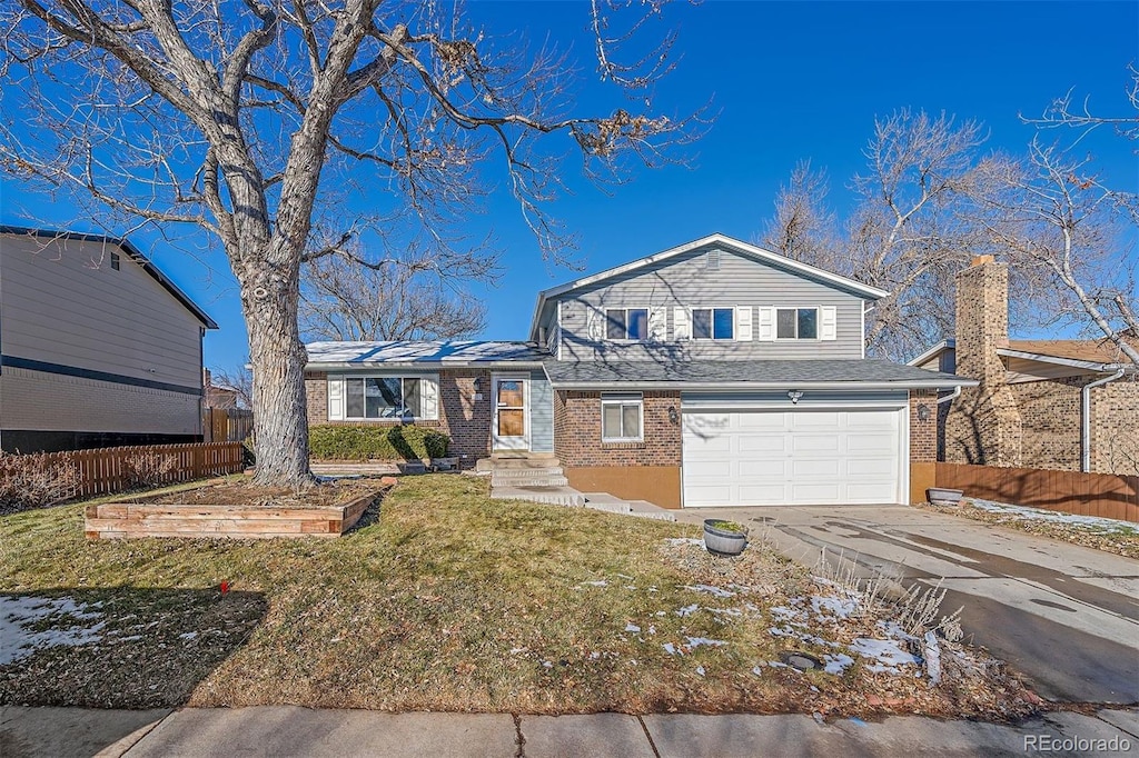 view of front of home with a front yard and a garage