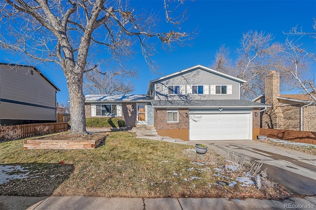 view of front of home with a front yard and a garage