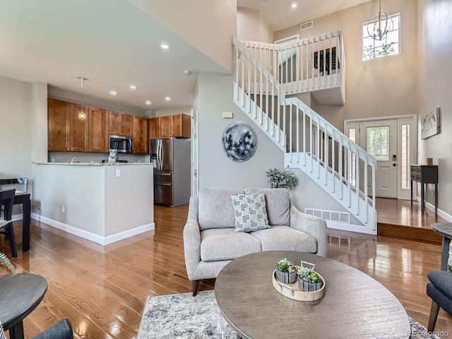 6827 S Webster St Unit E, Littleton, CO 80128 - living area with stairs, a towering ceiling, light wood finished floors, and recessed lighting