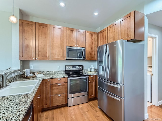 6827 S Webster St Unit E, Littleton, CO 80128 - kitchen with appliances with stainless steel finishes, light wood-style floors, brown cabinets, light stone countertops, and recessed lighting