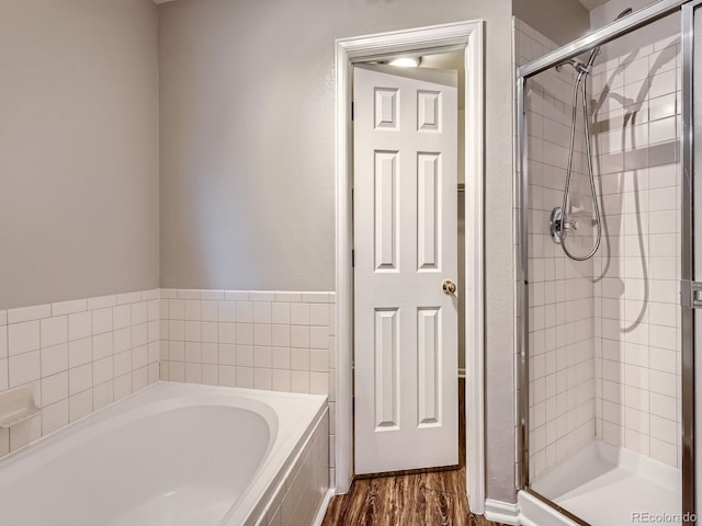 6827 S Webster St Unit E, Littleton, CO 80128 - full bathroom featuring a garden tub, a stall shower, and wood finished floors