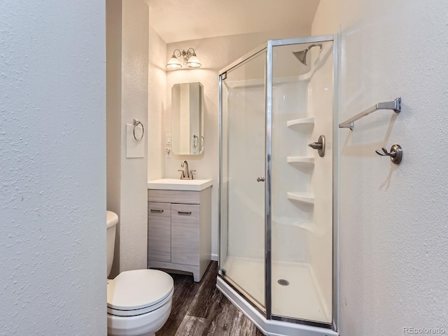 6827 S Webster St Unit E, Littleton, CO 80128 - bathroom with a textured wall, a stall shower, vanity, and wood finished floors