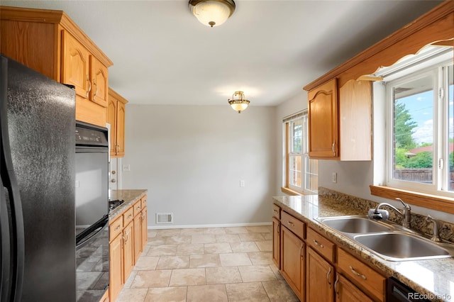 6698 S Wellington Ct, Centennial, CO 80121 - kitchen featuring black appliances, a sink, baseboards, and light countertops