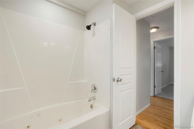 6698 S Wellington Ct, Centennial, CO 80121 - bathroom featuring wood finished floors, a combined bath / shower with jetted tub, and baseboards