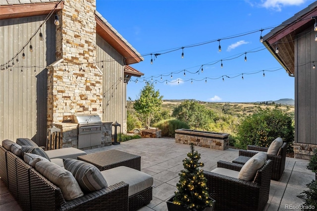 view of patio / terrace featuring exterior kitchen, an outdoor living space, and grilling area