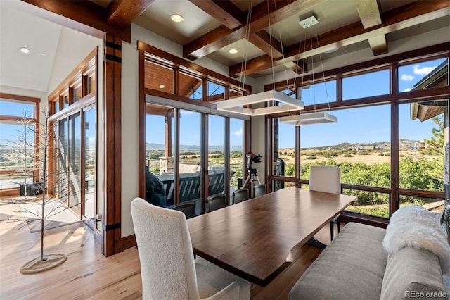 sunroom / solarium featuring vaulted ceiling with beams