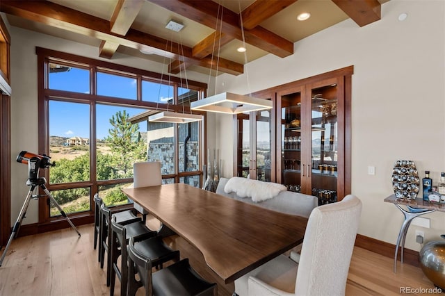 dining area with light wood-type flooring, coffered ceiling, beamed ceiling, and french doors