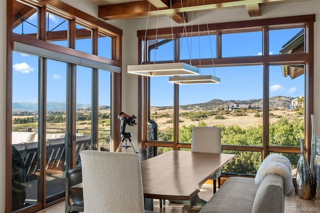 sunroom / solarium featuring a mountain view, beamed ceiling, and a rural view