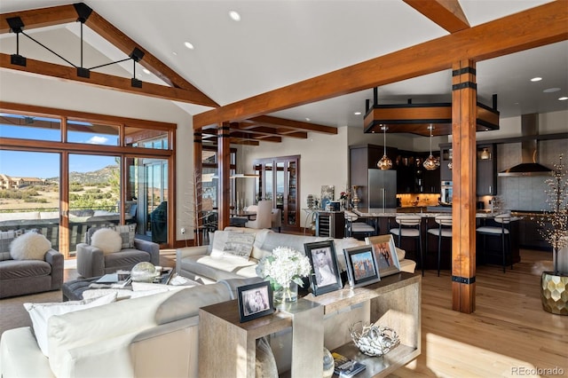 living room featuring light wood-type flooring, beam ceiling, and high vaulted ceiling