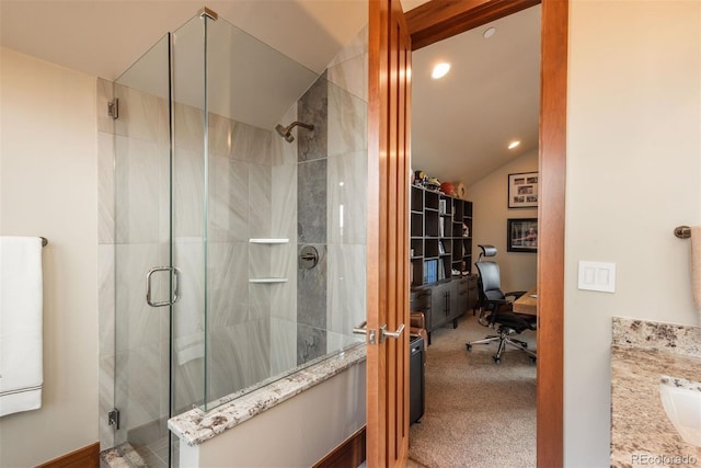 bathroom with lofted ceiling, walk in shower, and vanity