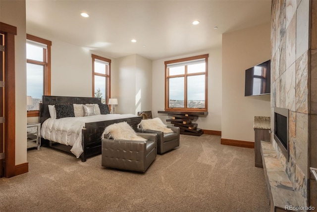 carpeted bedroom with multiple windows and a fireplace