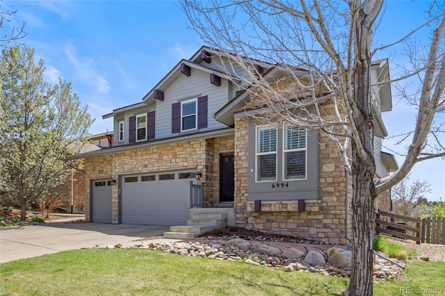 craftsman-style home with fence, a front lawn, stone siding, a garage, and concrete driveway