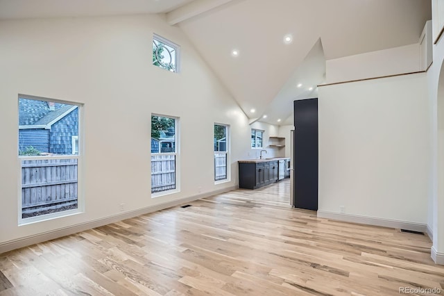 3975 Yates St, Denver, CO 80212 - unfurnished living room with high vaulted ceiling, light wood-style flooring, recessed lighting, and beamed ceiling