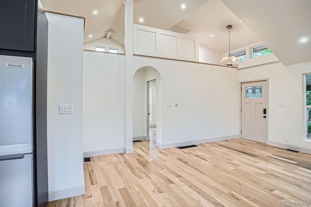 3975 Yates St, Denver, CO 80212 - kitchen featuring freestanding refrigerator, plenty of natural light, arched walkways, high vaulted ceiling, and light wood-style flooring