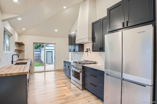 3975 Yates St, Denver, CO 80212 - kitchen with stainless steel appliances, butcher block countertops, premium range hood, light wood-style floors, and high vaulted ceiling