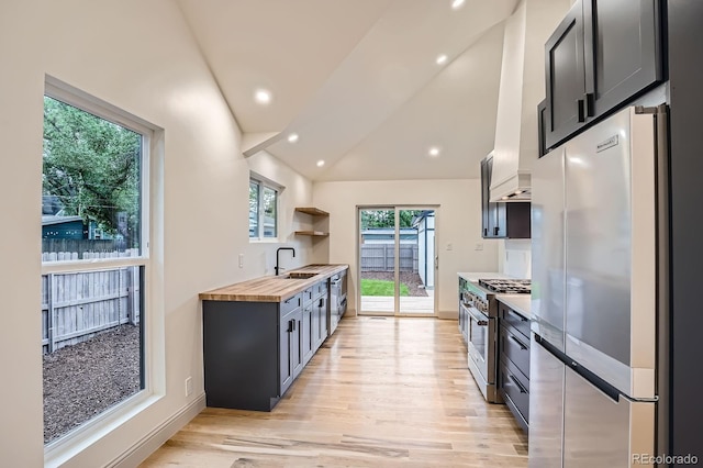 3975 Yates St, Denver, CO 80212 - kitchen featuring stainless steel appliances, light wood-style flooring, butcher block countertops, lofted ceiling, and open shelves