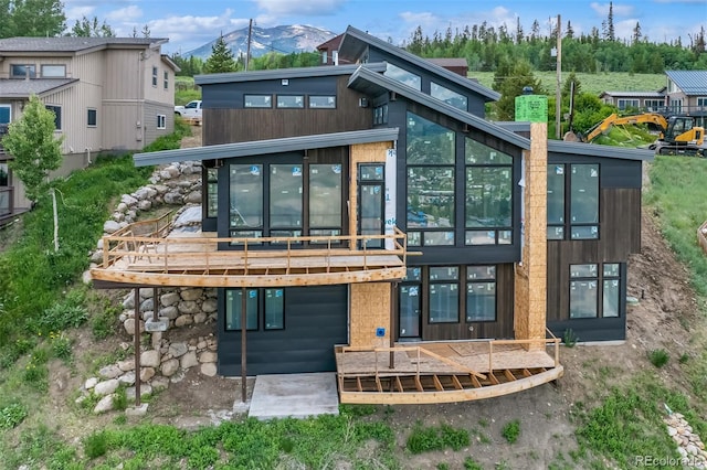 rear view of house with a deck with mountain view