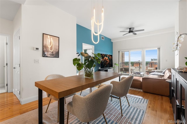 1950 N Logan St Unit 905, Denver, CO 80203 - dining area featuring ceiling fan, light wood finished floors, a chandelier, and baseboards