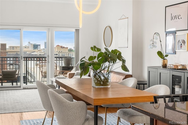 1950 N Logan St Unit 905, Denver, CO 80203 - dining space featuring wood finished floors, a city view, and healthy amount of natural light
