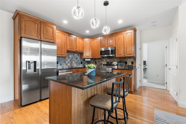 1950 N Logan St Unit 905, Denver, CO 80203 - kitchen featuring stainless steel appliances, light wood-style flooring, baseboards, decorative backsplash, and recessed lighting