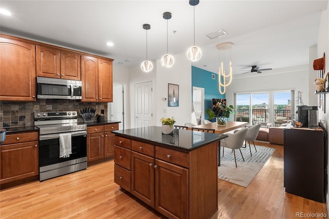 1950 N Logan St Unit 905, Denver, CO 80203 - kitchen with stainless steel appliances, tasteful backsplash, open floor plan, a ceiling fan, and light wood-type flooring