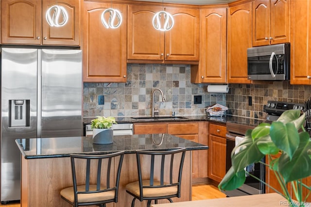 1950 N Logan St Unit 905, Denver, CO 80203 - kitchen with appliances with stainless steel finishes, a sink, a breakfast bar, backsplash, and brown cabinets