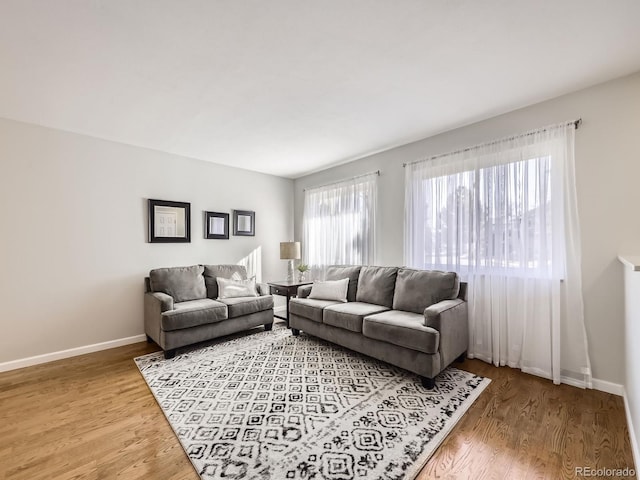 living area featuring light wood-type flooring and baseboards