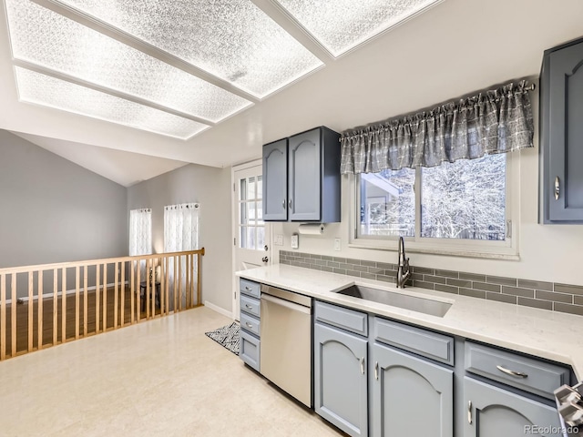 kitchen featuring lofted ceiling, light countertops, dishwasher, and a sink