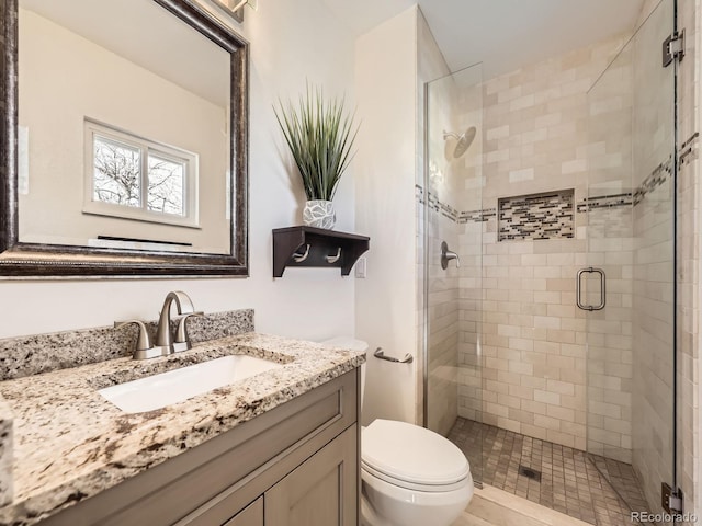 full bath featuring a stall shower, vanity, and toilet