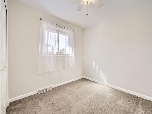 empty room featuring carpet, visible vents, ceiling fan, and baseboards