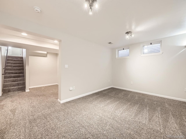 basement featuring stairs, carpet flooring, visible vents, and baseboards