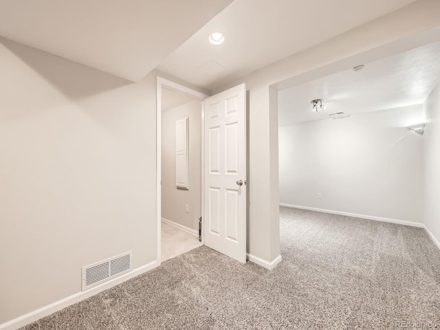 basement with carpet floors, baseboards, and visible vents