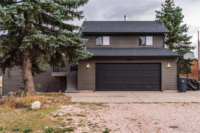 view of front of home featuring driveway, a shingled roof, and a garage