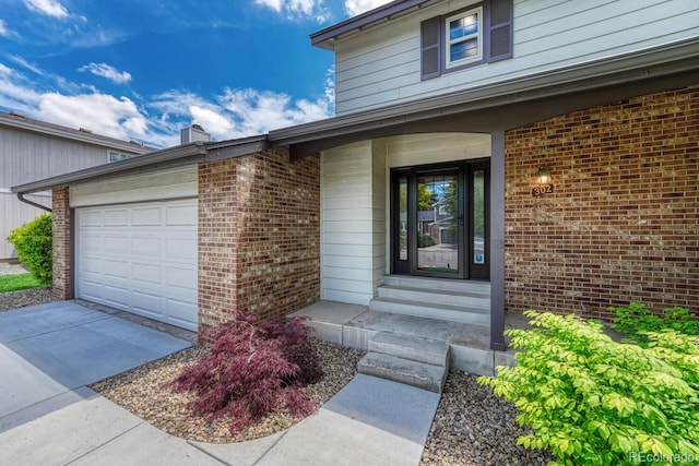 302 Northridge Rd, Highlands Ranch, CO 80126 - view of exterior entry with brick siding, an attached garage, and concrete driveway