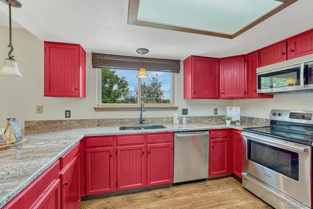 302 Northridge Rd, Highlands Ranch, CO 80126 - kitchen with appliances with stainless steel finishes, a sink, light wood-style floors, pendant lighting, and reddish brown cabinets