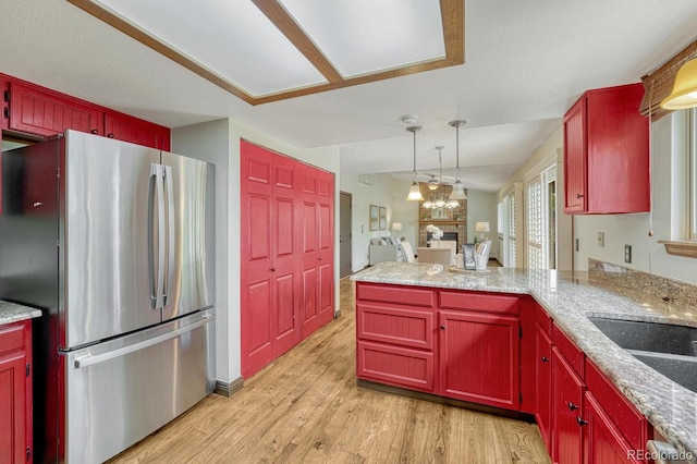 302 Northridge Rd, Highlands Ranch, CO 80126 - kitchen with freestanding refrigerator, light wood finished floors, a peninsula, pendant lighting, and reddish brown cabinets