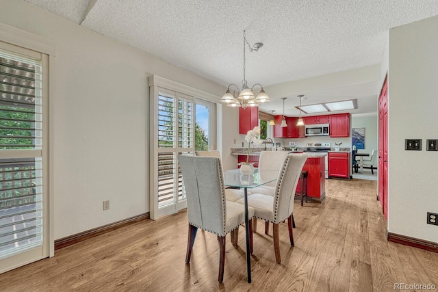 302 Northridge Rd, Highlands Ranch, CO 80126 - dining space featuring a chandelier, light wood-type flooring, a textured ceiling, and baseboards