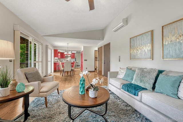 302 Northridge Rd, Highlands Ranch, CO 80126 - living room with a wall unit AC, light wood finished floors, vaulted ceiling, a ceiling fan, and a textured ceiling